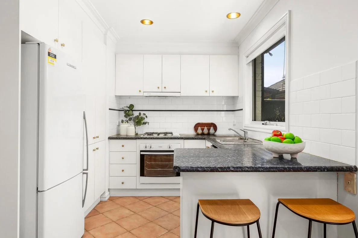 Green Eggs and Ham kitchen before renovation — original white cabinetry and speckled benchtop